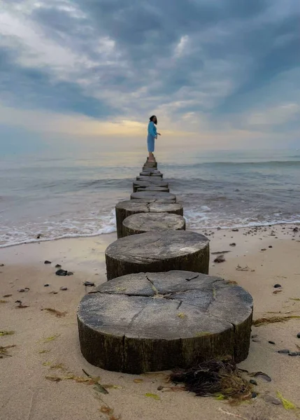 Vertical Shot Girl Standing Wooden Stump Beach Surrounded Ocean — Stock Photo, Image