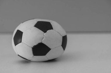 Arka planda bulanık duran eski bir siyah beyaz futbol topunun yakın plan çekimi.