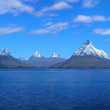 Gökyüzünün altında dağlar olan güzel bir göl manzarası.