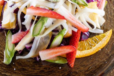 Kahverengi tabakta taze meyve salatasının yakın çekimi.