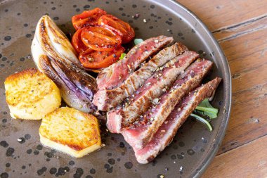 Tabakta ızgara et ve sebzelerin yakın plan çekimi.