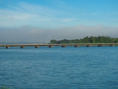 Mavi gökyüzünün altında denizin üzerindeki güzel bir köprü manzarası.