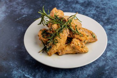 Mavi masada kuru biberiyeyle servis edilen bir tabak lezzetli kızarmış tavuğun yakın çekimi.