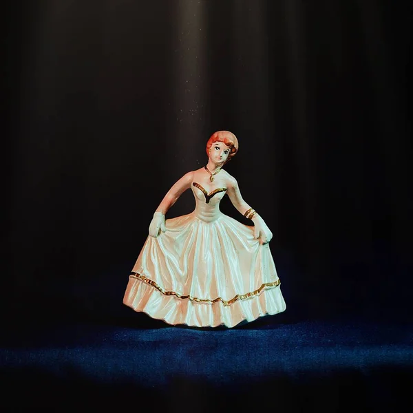 一个可爱的芭蕾舞演员的特写在蓝色的表面在黑暗的背景下 — 图库照片