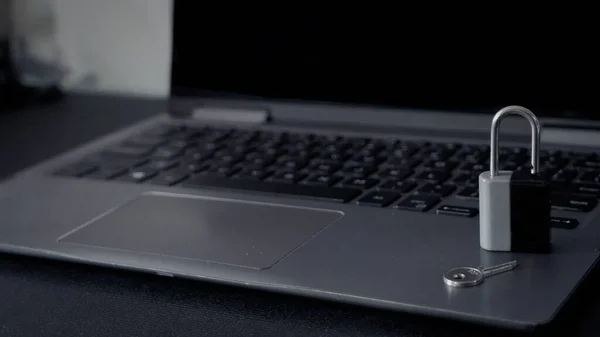 A closeup shot of silver and black lock and key on laptop