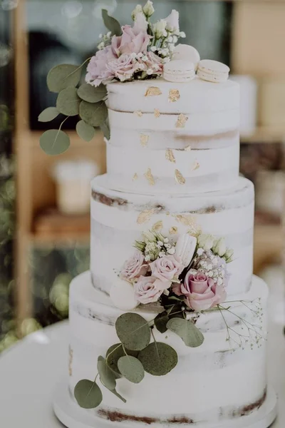 一个白色结婚蛋糕的垂直视图 上面有花朵和华丽的装饰 — 图库照片
