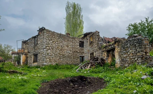 Gamle Ødelagte Stenbygninger Græshave Forladt Landsby Nordmakedonien Med Overskyet Himmel - Stock-foto
