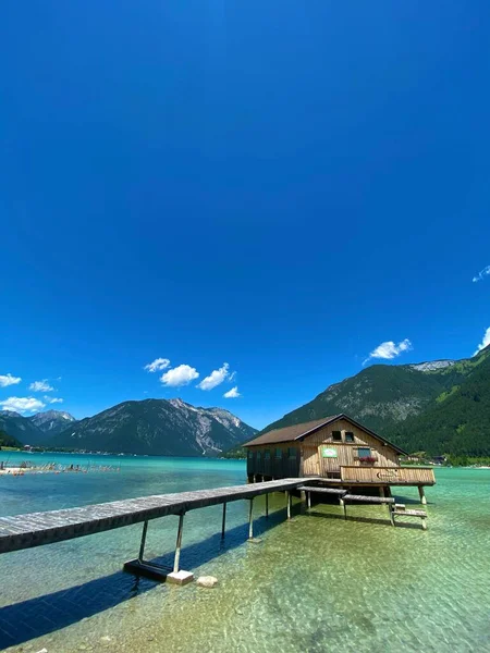 Lago Tranquilo Rodeado Montañas Con Una Casa Sobre Agua Primer — Foto de Stock