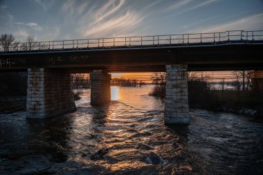 Yazın Montreal, Kanada 'da günbatımında göl ve ağaçlarla çevrili büyüleyici bir köprü manzarası
