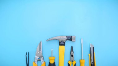 Mavi arkaplanda bir satırda sarı tamir araçlarının üst görünümü