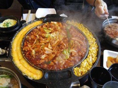 Restoran masasının ortasında mısırlı seksi Dak-galbi manzarası.