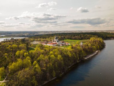 Pasaislis Manastırı 'nın havadan görünüşü göl kenarında büyüyen ağaçlar ve yeşilliklerle çevrilidir.
