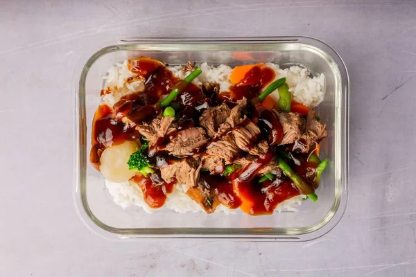 在透明的盘子里放上切碎的牛肉 米饭和酱汁作为食物的上图 — 图库照片