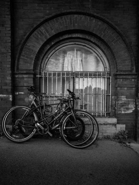 Снимок Велосипедов Оттенках Серого Прислоненный Стене Окном Торонто Канада — стоковое фото