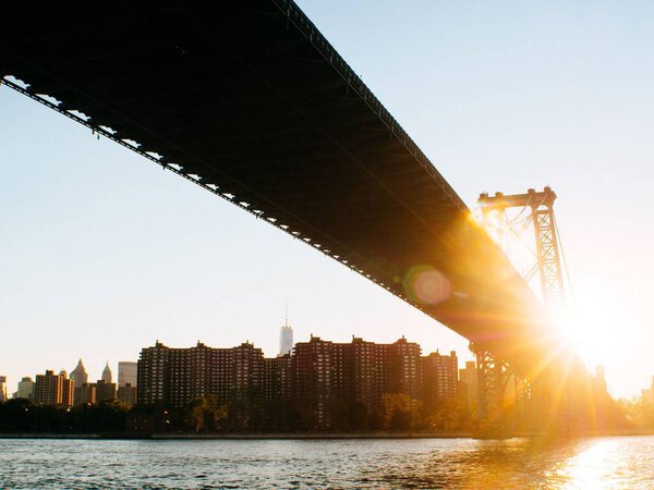 The sun shining behind the Manhattan bridge