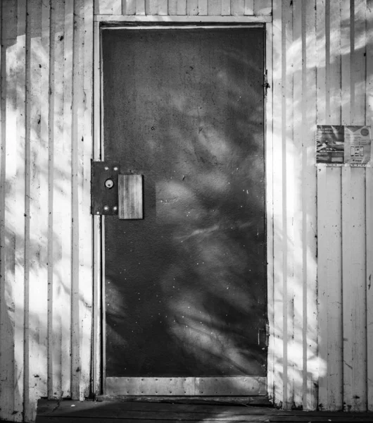 田舎の小さな家の古いドアの灰色のショット — ストック写真