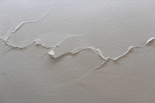 A Crack on the wall like a the tendon breaks into parts and going ahead. The plaster is breaking out from the wall