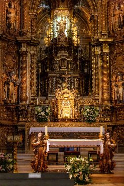 Güzel altın heykeller ve simgelerle bir katedralin sunağının dikey görüntüsü.