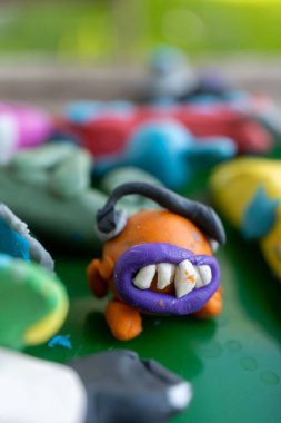 Turuncu renkli kilden canavar bir karakterin dikey görüntüsü