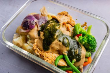 Tavuk, patates, şeffaf tabakta mantar soslu sebze.