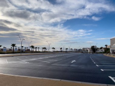 Arka planda gündoğumu gökyüzü olan boş bir otopark