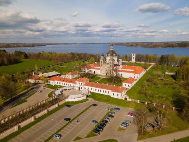 Pasaislis Manastırı 'nın havadan görünüşü göl kenarında büyüyen ağaçlar ve yeşilliklerle çevrilidir.