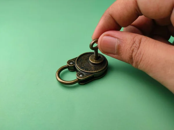 Een Hand Vergrendeling Een Bronzen Vintage Hangslot Zacht Groen Papier — Stockfoto