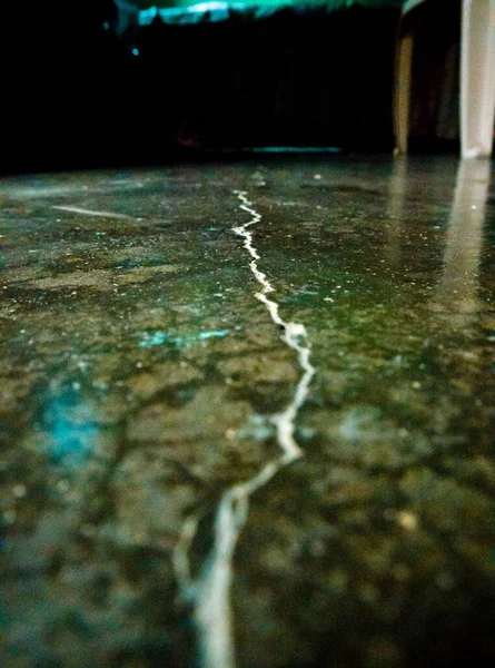 床の上に亀裂 黒い床は真ん中に亀裂がある — ストック写真