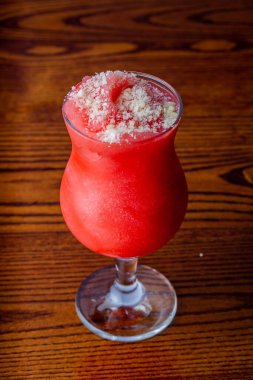 Tahta masada bir bardak karpuz suyunun dikey görüntüsü.