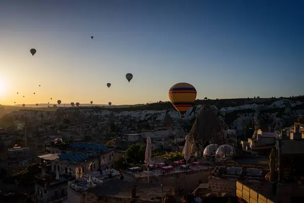 日の出 カッパドキア トルコで山や建物の上を飛ぶ熱気球の空中ビュー — ストック写真