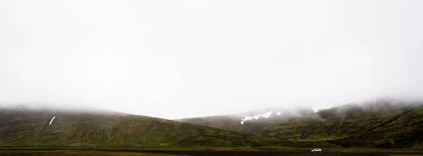 Zdjęcie Boczne Samochodu Jadącego Drodze Otoczonego Górami Mglistą Pogodę — Zdjęcie stockowe