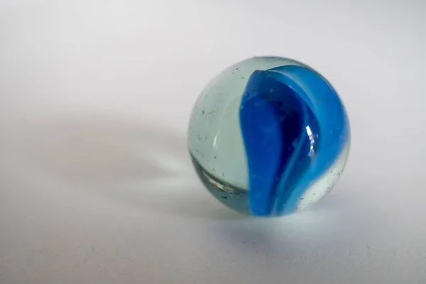 Egy Közeli Felvétel Egy Kék Üveggolyóról Egyszerű Háttérrel — Stock Fotó