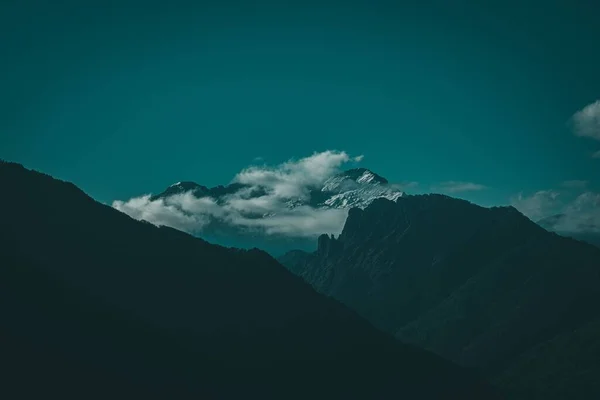 Een Adembenemend Landschap Met Bergtoppen Die Witte Wolken Blauwe Lucht — Stockfoto