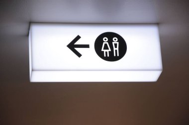 Solunda erkek ve kadın sembolleri ve okları olan neon ışıklı bir tabela.