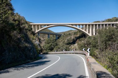 Mavi gökyüzünün altında güneşli bir günde otoyolun ve banliyö üst geçidinin güzel bir manzarası