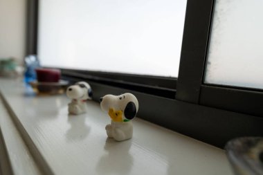 Pencerenin kenarına yerleştirilmiş küçük Snoopy Dog modelinin seçici bir odak noktası.