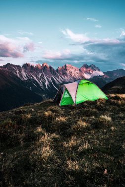 Bu güzel manzaraya karşı dağın zirvesinde bir yürüyüş çadırının dikey görüntüsü
