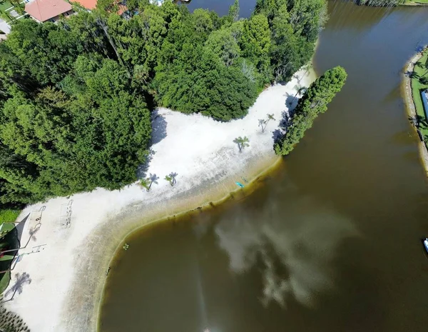 緑の木々に覆われた砂浜の海岸に対する海の空上の景色 — ストック写真