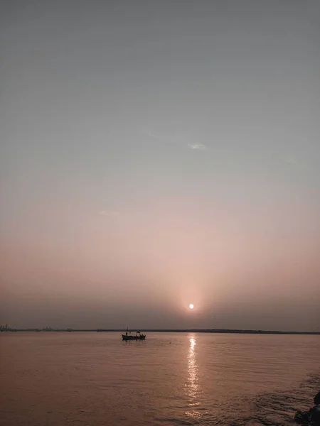 日没時に海に浮かぶ船の縦のシルエット — ストック写真