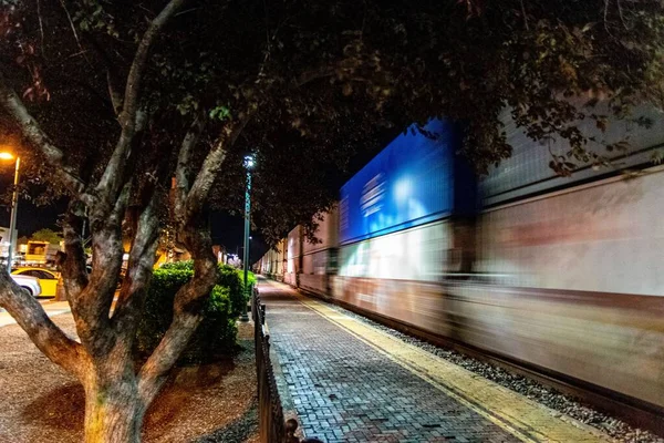 Uma Longa Exposição Comboio Mercadorias Que Atravessa Cidade Noite — Fotografia de Stock
