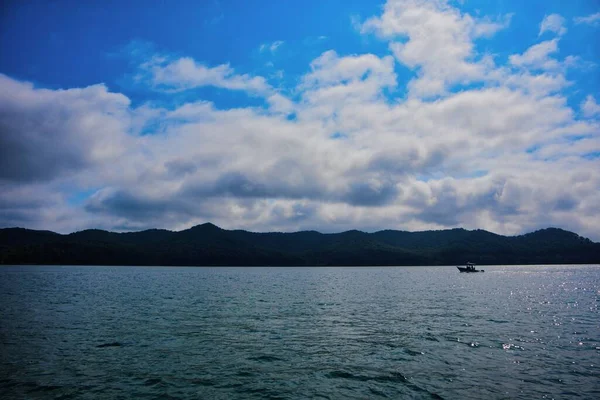 山のある湖の水平線と上の雲の空のパノラマのショット — ストック写真