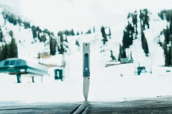 Närbild Bild Bild Jaktkniv Trädstam Med Snöiga Berg Suddig Bakgrund — Stockfoto