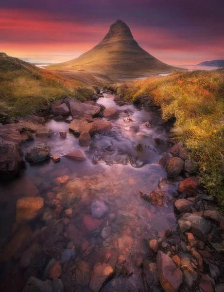 Pionowe Ujęcie Jeziora Kamieniami Piękne Wzgórze Tle Kolorowego Zachodu Słońca — Zdjęcie stockowe
