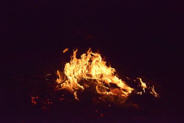 Karanlıkta alevler içinde bir kamp ateşi