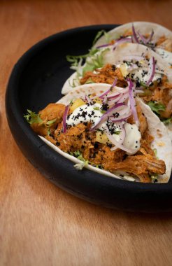 Siyah bir kasede taze taco al pastor yakın plan.