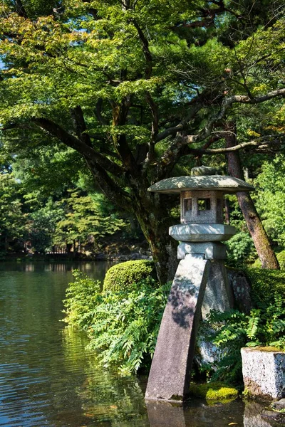 日本庭園の湖による石灯籠の垂直ショット — ストック写真