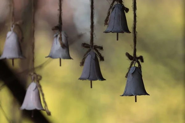 A closeup shot of small bells hanging from the top outdoors