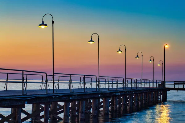 Eine Strandpromenade Auf Dem Wasser Mit Lichtern Bei Sonnenuntergang — Stockfoto