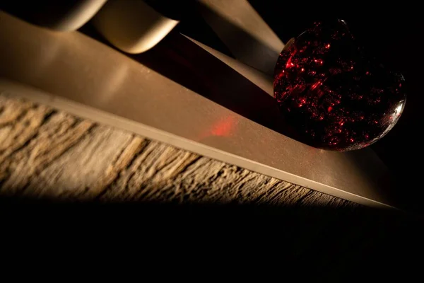 A round sparkly ball placed on a wooden surface with limited light in the room