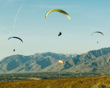 ABD 'nin Utah eyaletindeki Salt Lake City' deki Dağın Noktası yakınlarında uçan üç paraşütçü.